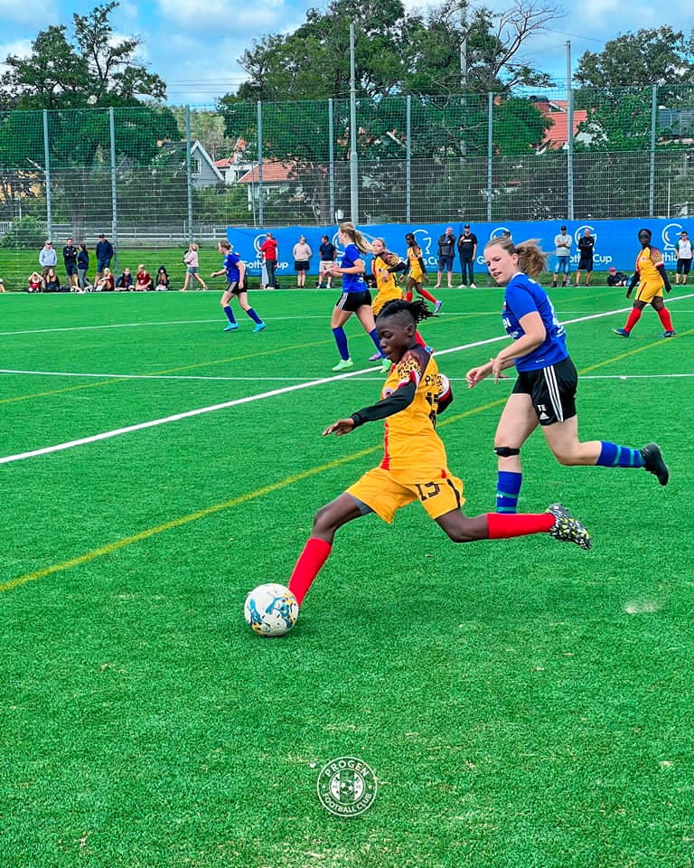 A ProGen FC player in yellow strikes the ball during a tournament match