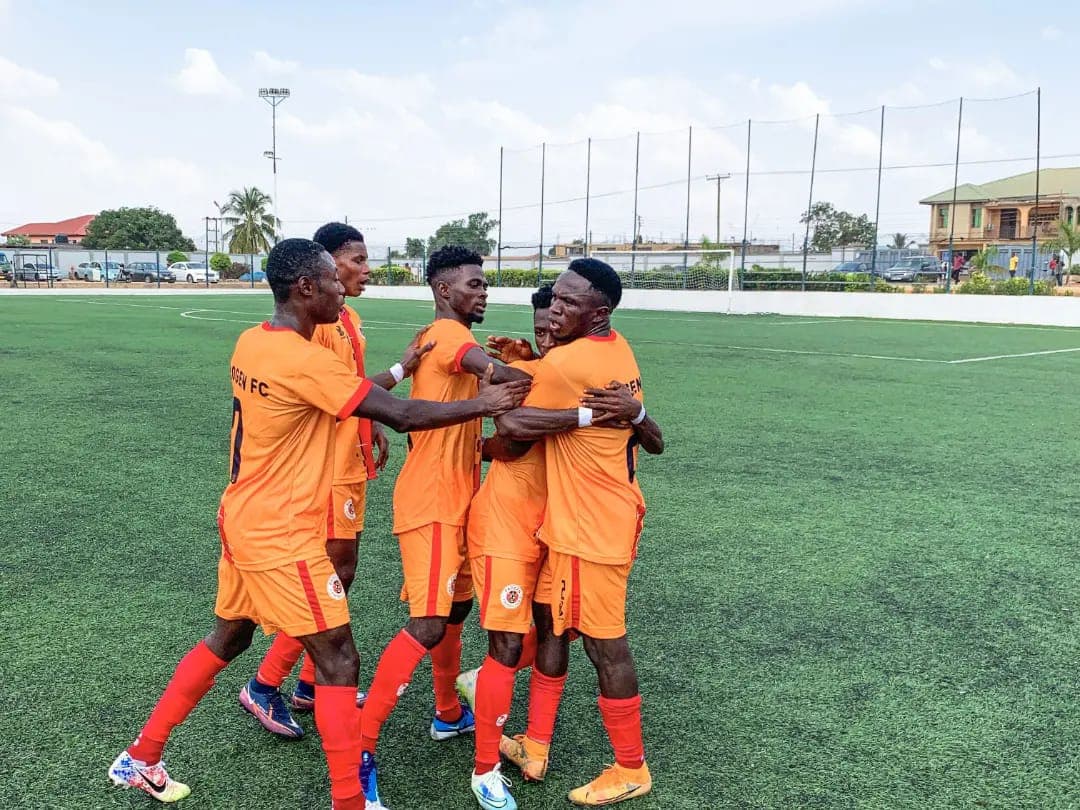 ProGen FC first-team players in orange kits celebrating a goal together